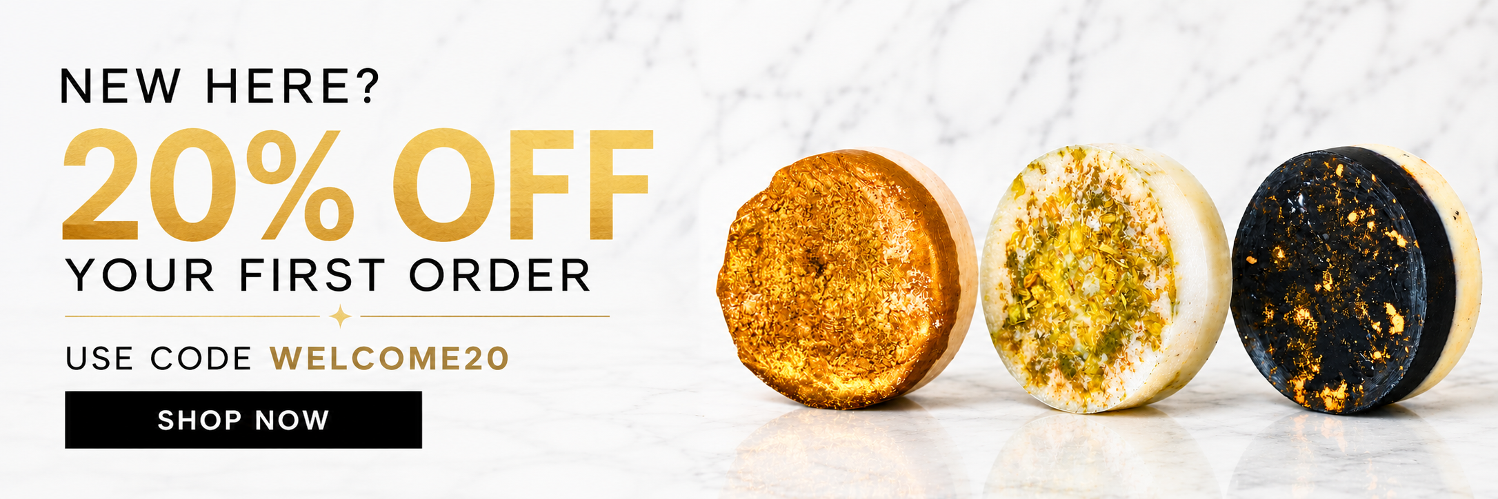 Promotional banner with text reading 'NEW HERE? 20% OFF YOUR FIRST ORDER' and 'USE CODE WELCOME20 SHOP NOW,' alongside three round decorative soaps on a white marble surface.